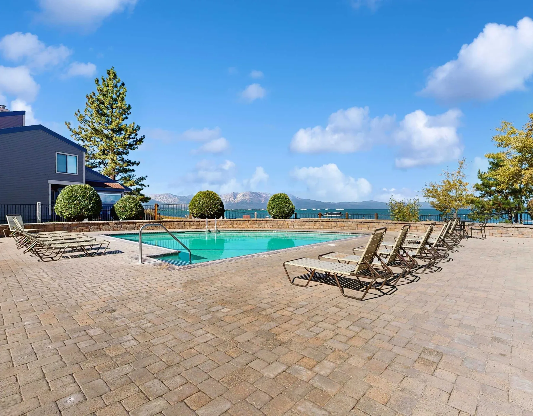Shared amenity: Outdoor swimming pool surrounded by paved deck and lounge chairs.