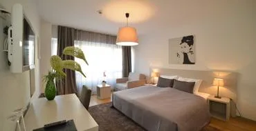 Representative hotel space: A bedroom with two beds, bedside lamps, and a desk by the window.