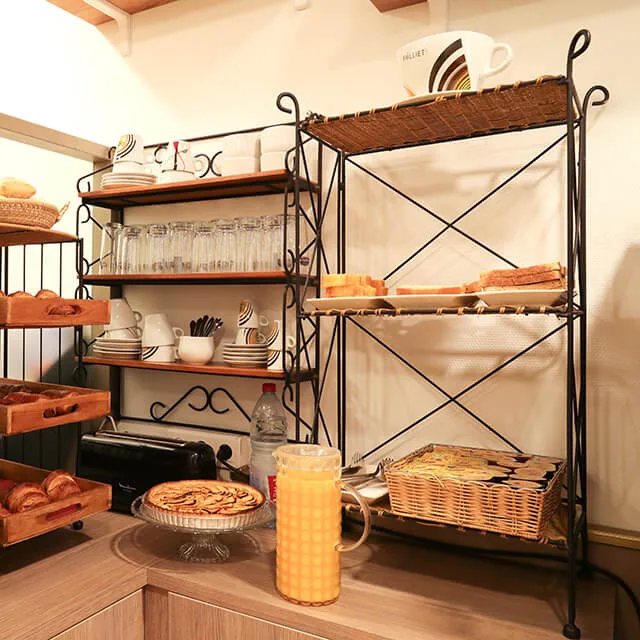 Representative hotel space: A buffet counter displays pastries, drinks, and tableware on open shelves.