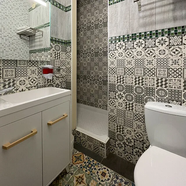Representative hotel space: A bathroom with patterned tile walls and a sink.