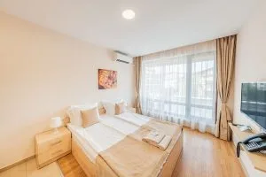 Representative hotel space: A bright bedroom with a bed beside a large curtained window.