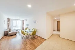 Representative hotel space: Bright living and dining area with seating and a table beside large windows.