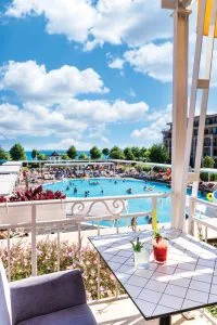 Representative hotel space: A balcony seating area overlooks an outdoor swimming pool.