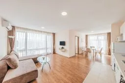 Representative hotel space: A bright living and dining area with large windows and wood flooring.