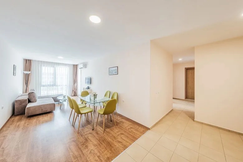 Representative hotel space: A bright living and dining area with seating beside a large window.