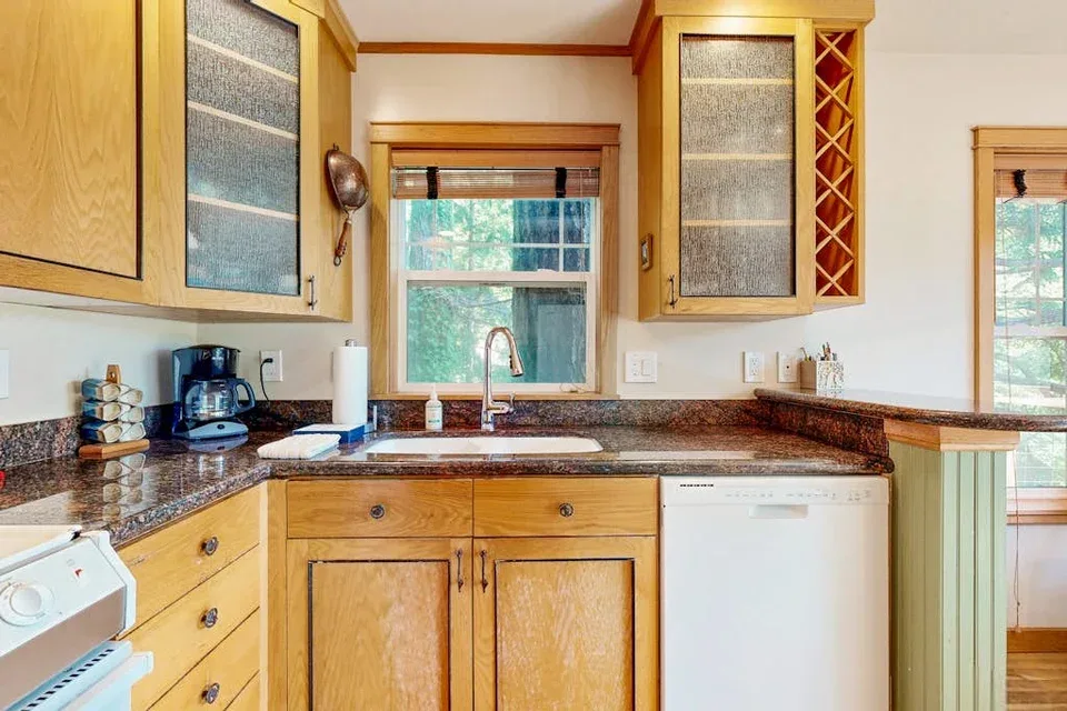 Una cocina con gabinetes de madera, un fregadero y un lavavajillas.