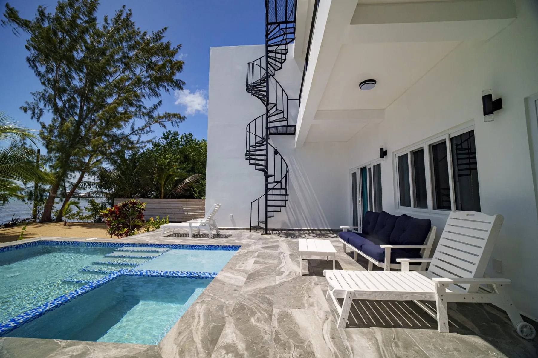 Shared amenity: Poolside patio with lounge seating beside the building.