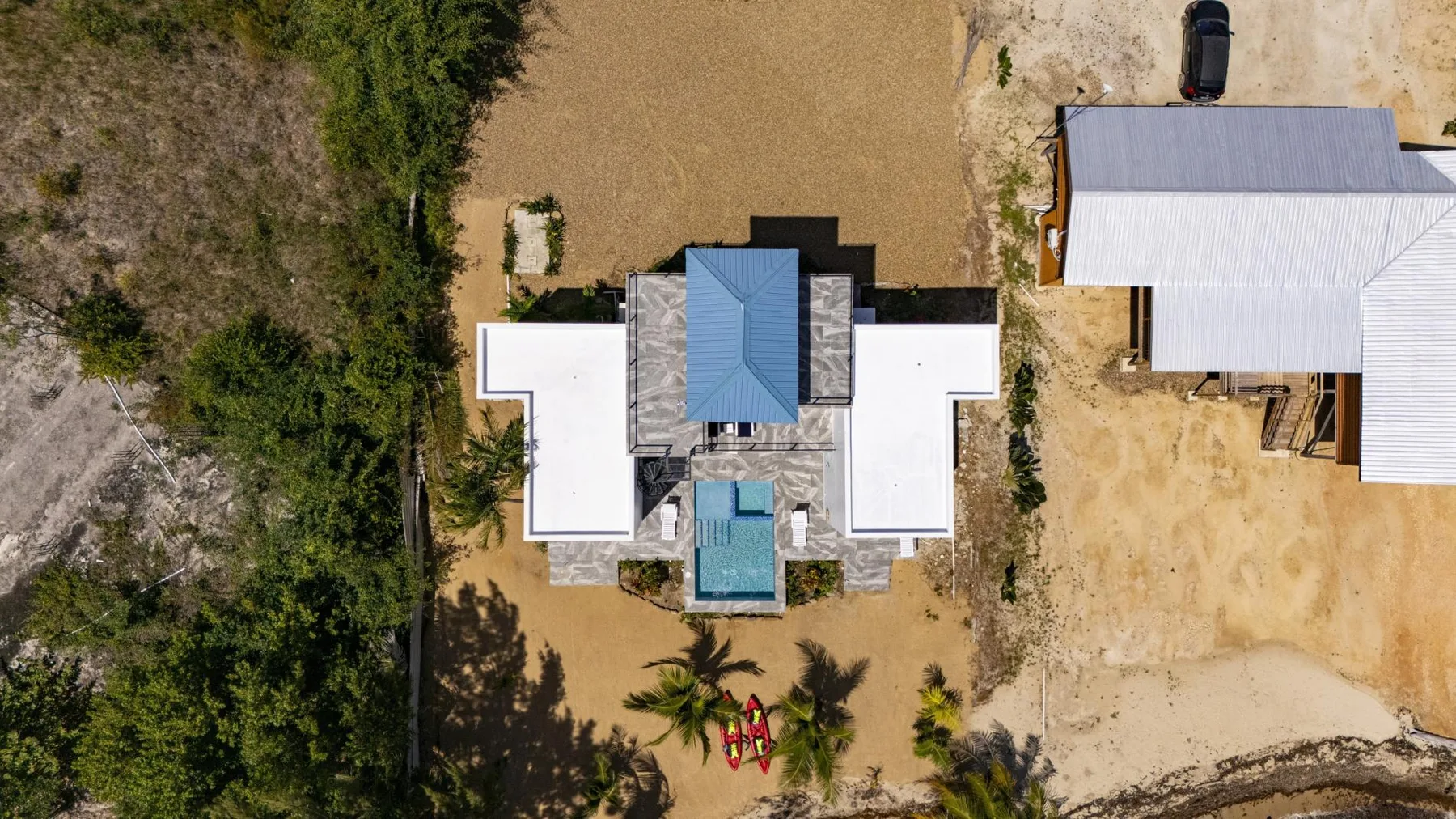 Shared amenity: An aerial view shows a building with white roof sections amid dry, sandy ground.
