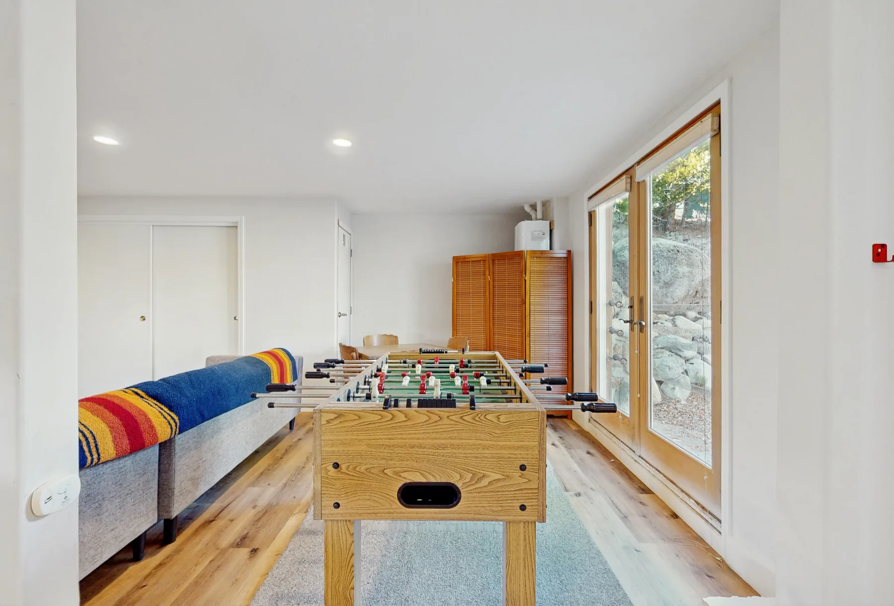 Una luminosa sala de juegos con una mesa de futbolín y asientos.