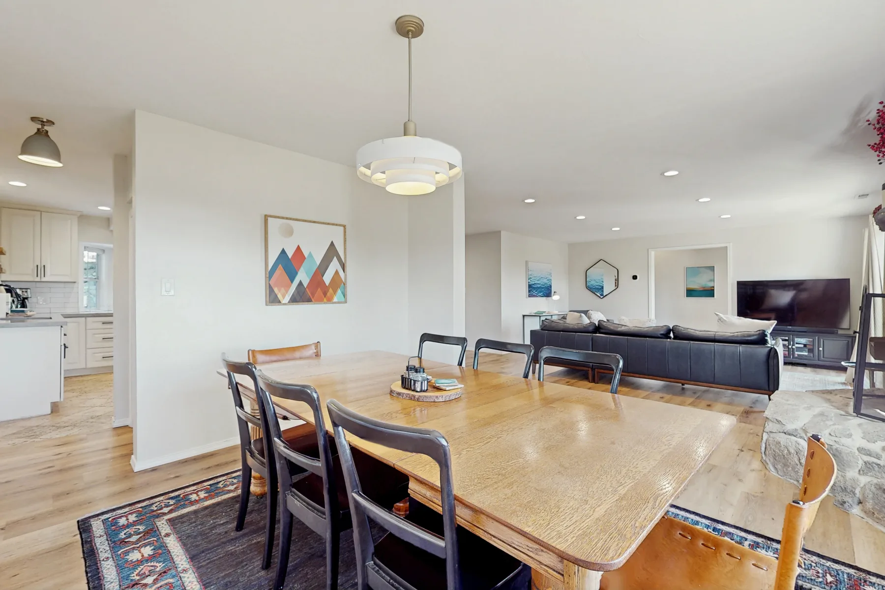 Salón-comedor de planta abierta con una mesa de madera y asientos.
