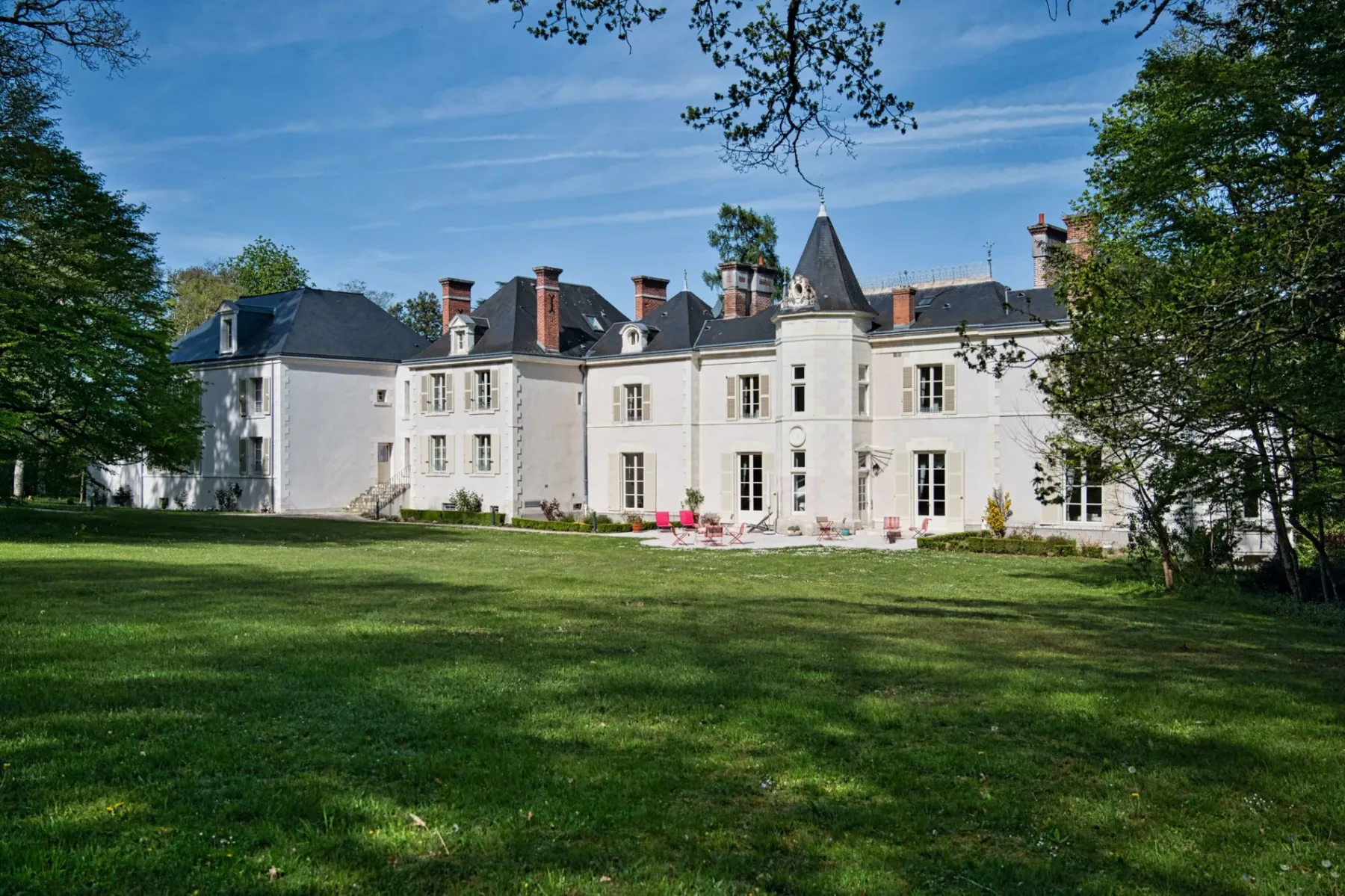 Representative hotel space: A large pale stone building stands beyond a broad green lawn.