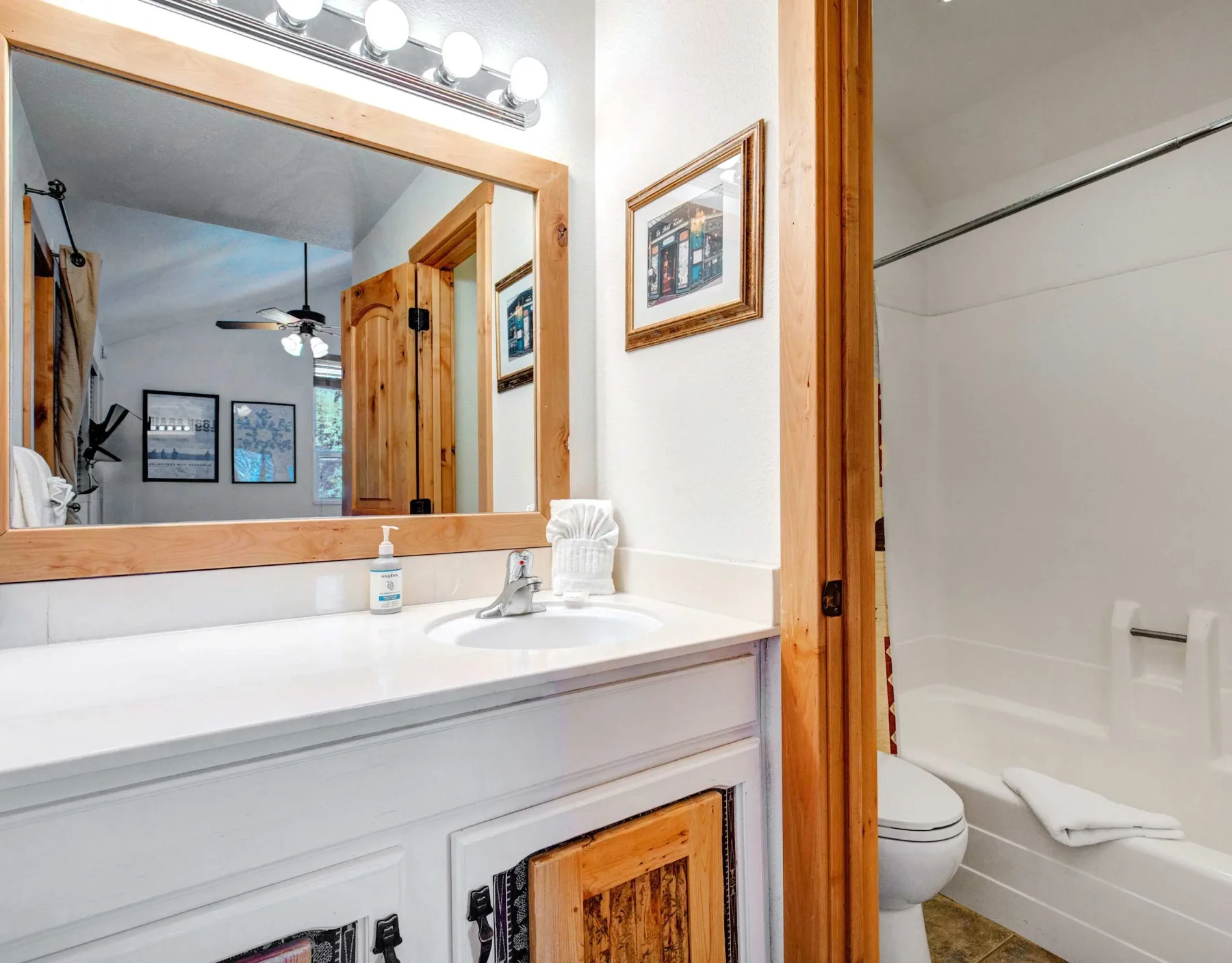 Un lavabo de baño con espejo junto a una bañera.