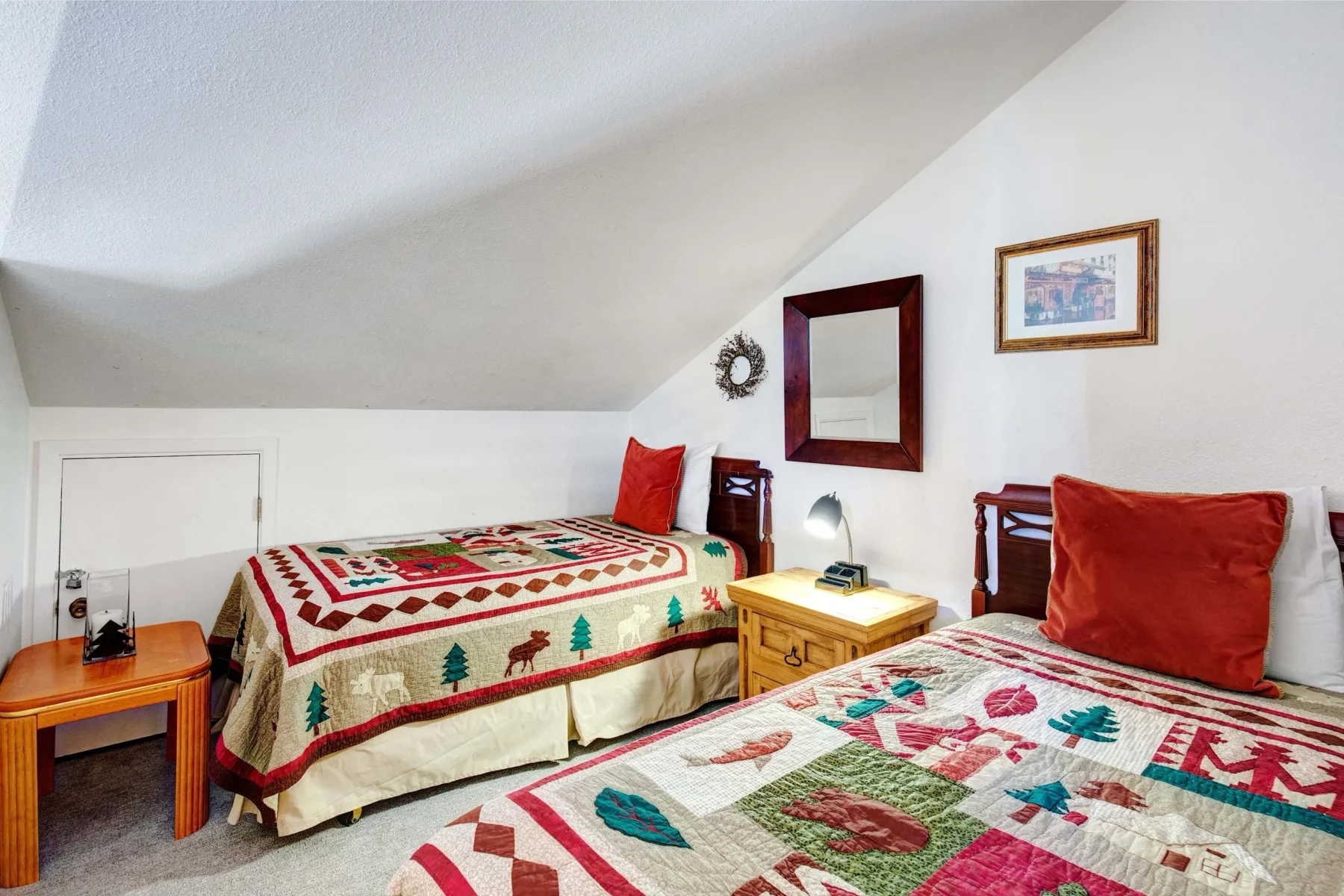 Un dormitorio con dos camas cubiertas con colchas coloridas estampadas.