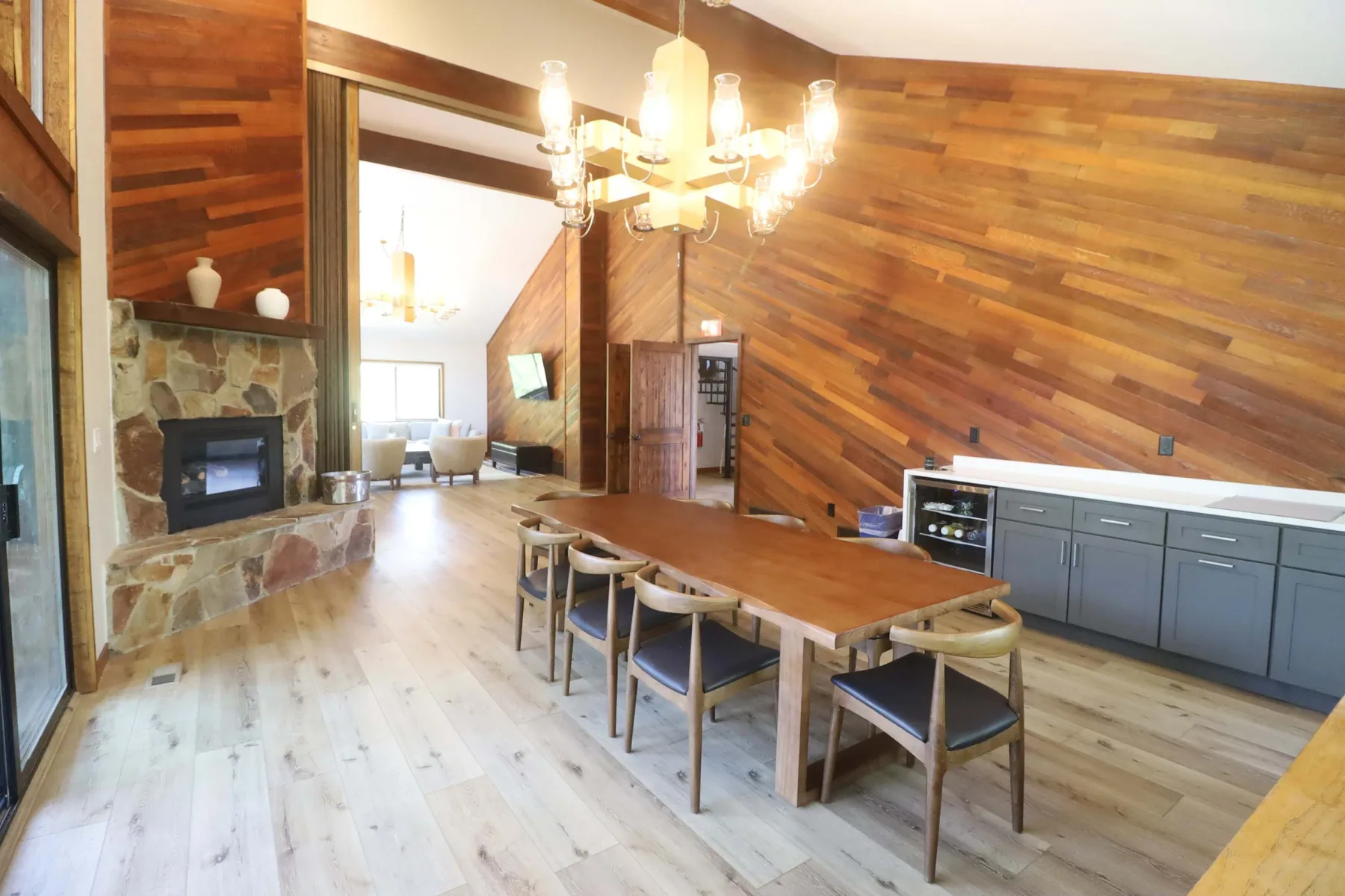 Zona común: Un amplio comedor con una mesa larga, asientos y una chimenea de piedra.