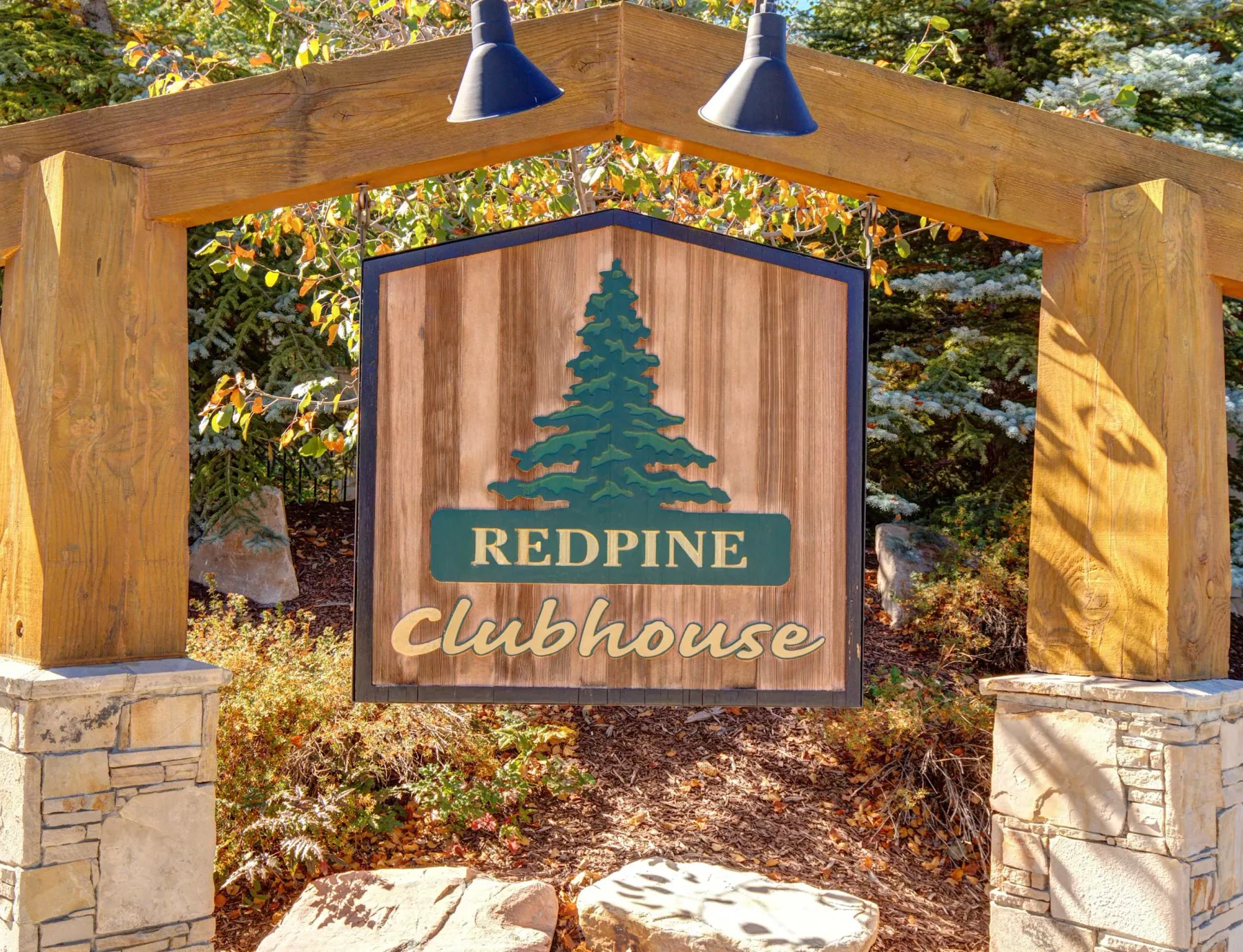 Zona común: Un letrero de madera indica el club Redpine, rodeado de follaje otoñal.