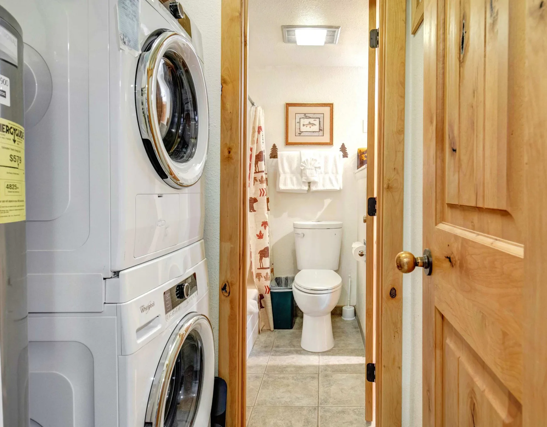 Una zona de lavandería da a un baño con inodoro y lavabo.