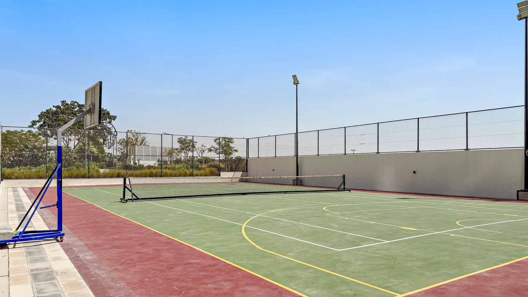 Shared amenity: An outdoor sports court with basketball hoops and painted playing lines.