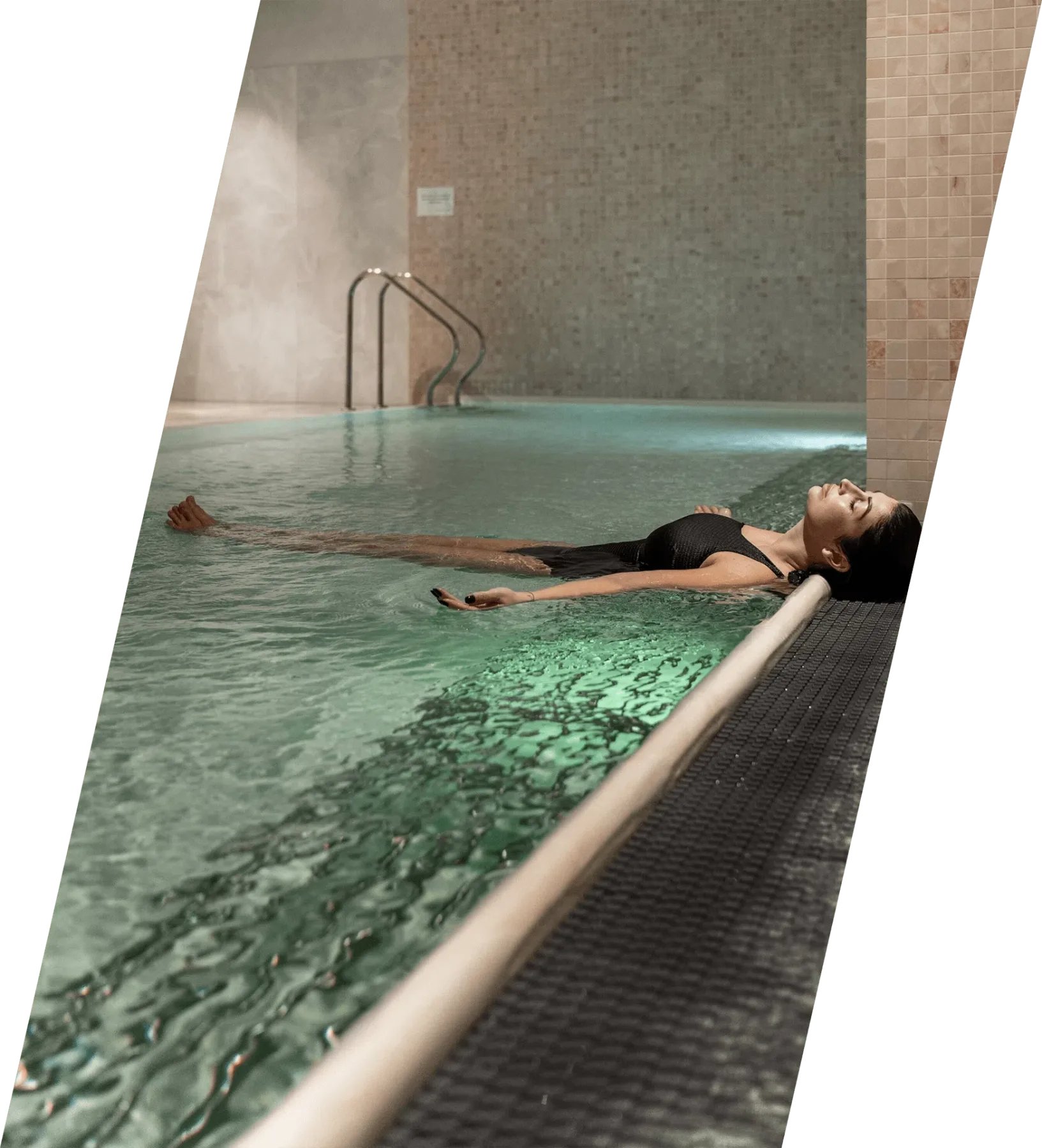 Espacio representativo del hotel: Una piscina cubierta con una persona flotando en el agua.