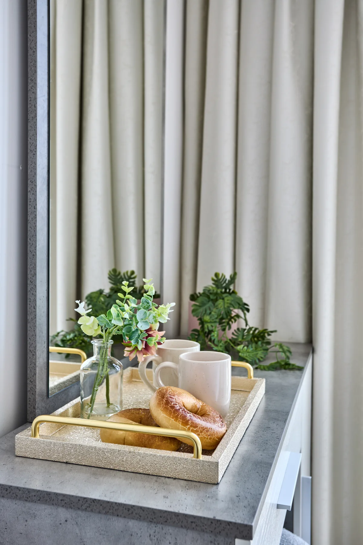 A refreshment tray sits on a counter beside the window and curtains.