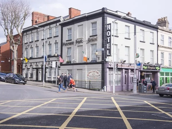 Espacio representativo del hotel: Un hotel está en una esquina junto a una intersección señalizada.