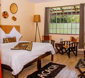 Representative hotel space: A bedroom with a bed, a tall window, and a small table with chairs.
