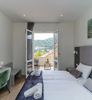 Representative hotel space: A bedroom with a bed beside open doors leading to a balcony.