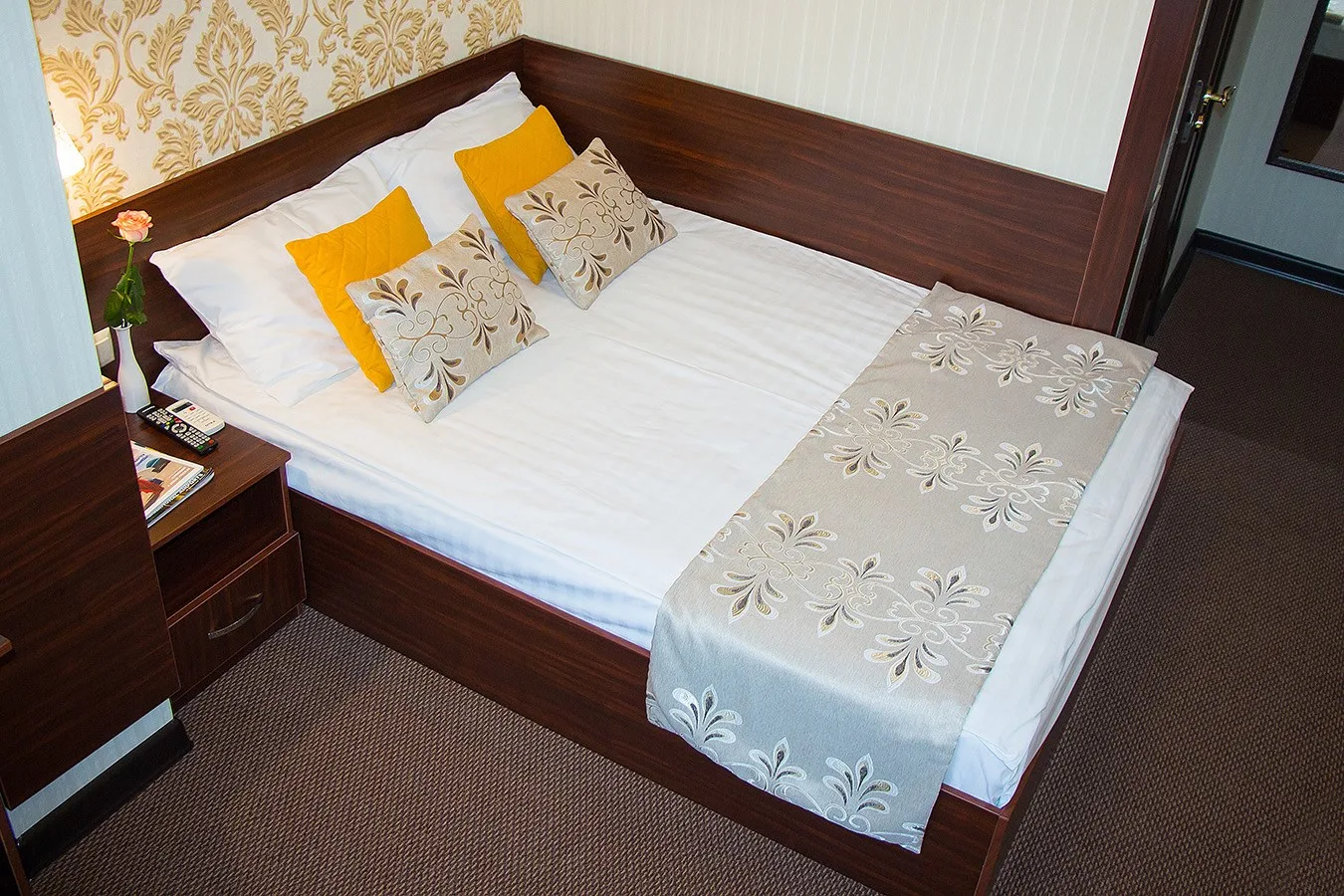 Espacio representativo del hotel: Un dormitorio con una cama vestida con ropa de cama blanca y estampada con flores.