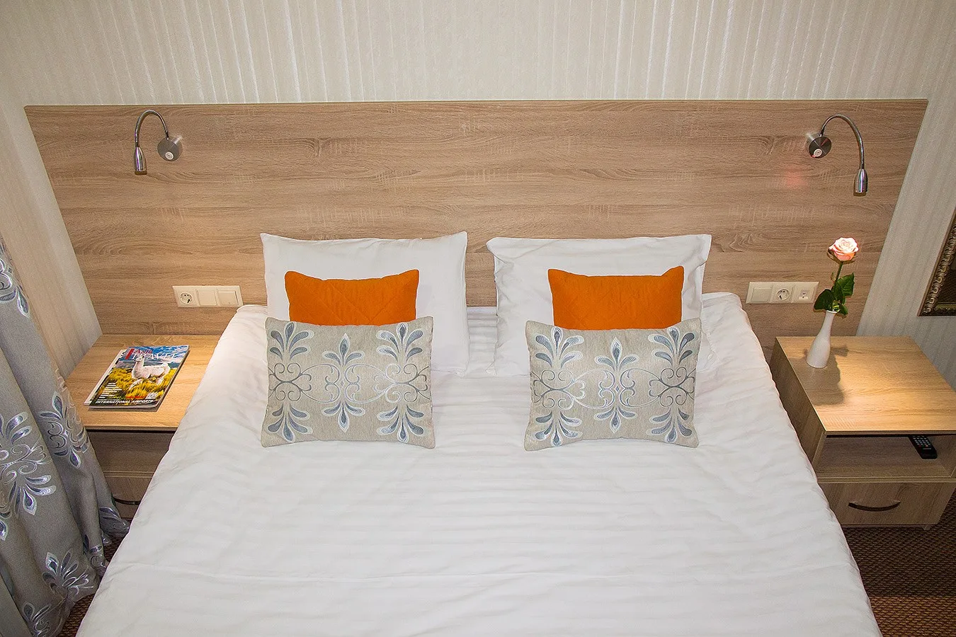 Espacio representativo del hotel: Un dormitorio con una cama bien hecha y mesitas de noche a juego.