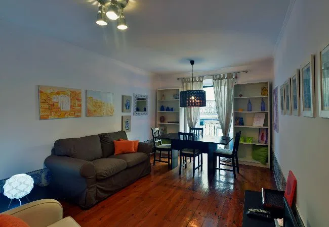 A living and dining area with seating, a table, and framed artwork.