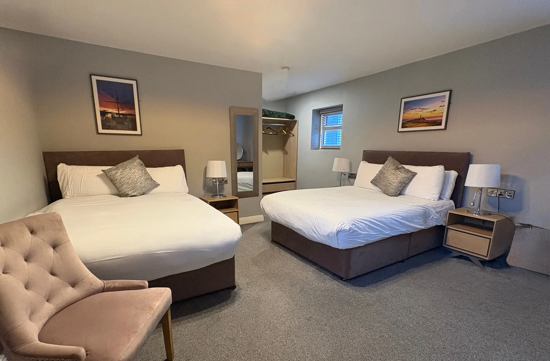 Espacio representativo del hotel: Un dormitorio con dos camas y una ventana entre ellas.