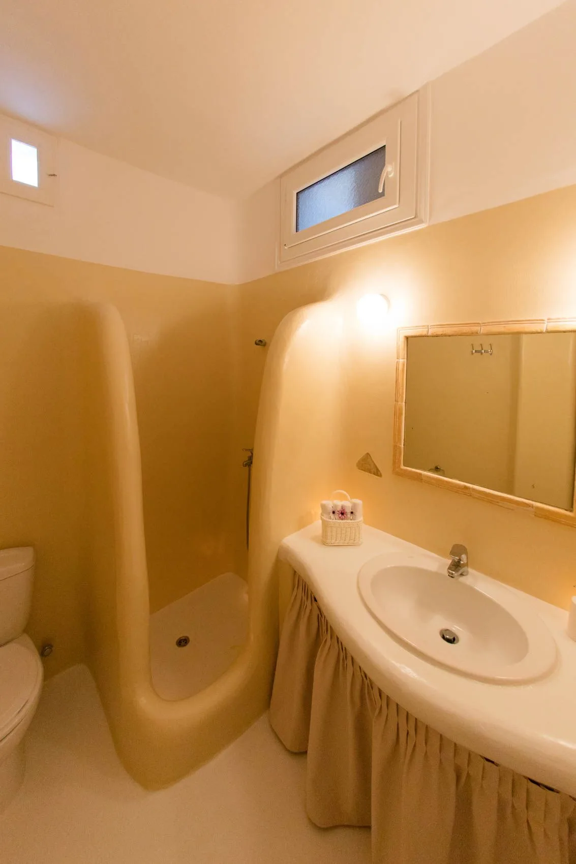 A bathroom with a sink, mirror, and shower.