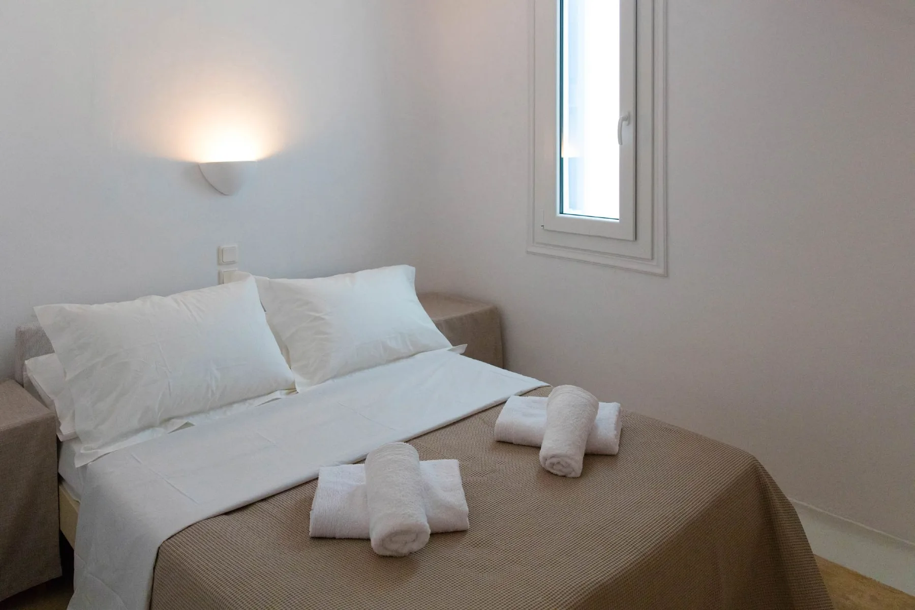 A bedroom with a neatly made bed and towels.