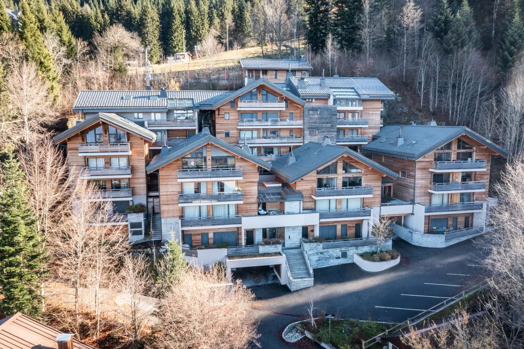 Shared amenity: A large multi-story building with balconies sits among wooded hills.