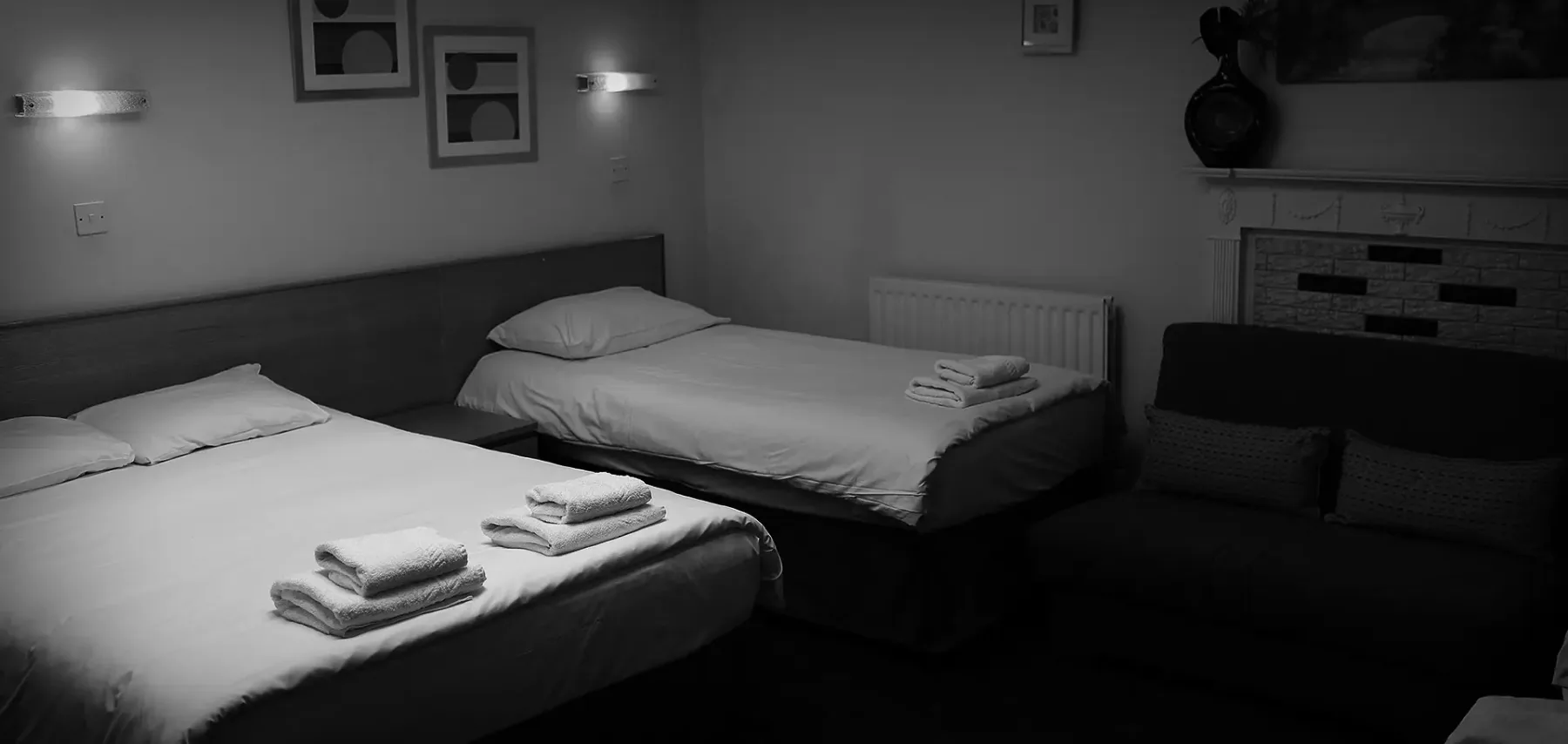 Espacio representativo del hotel: Un dormitorio con dos camas y toallas dobladas ordenadamente.