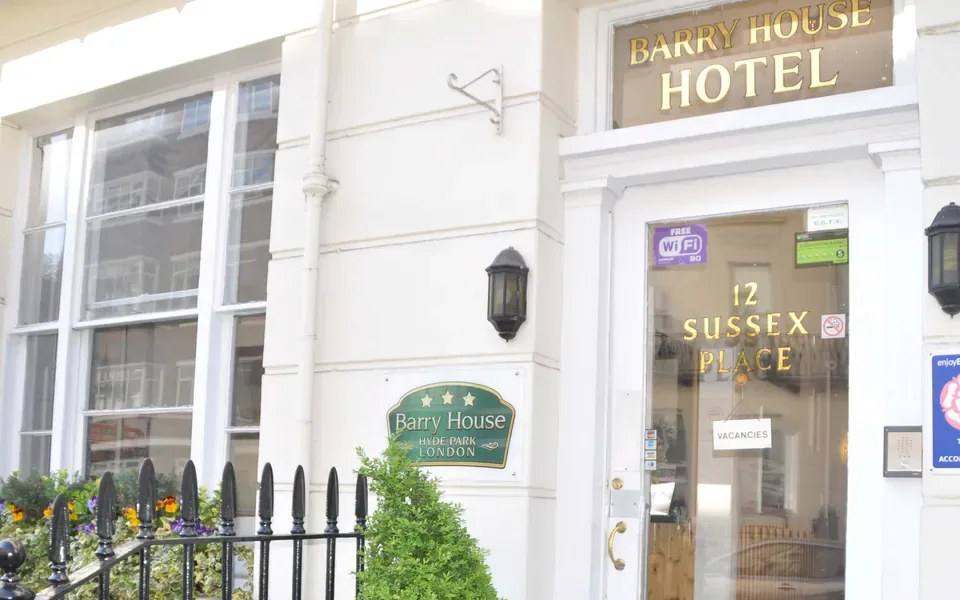 Espacio representativo del hotel: La entrada del hotel tiene una puerta de vidrio y un letrero encima.