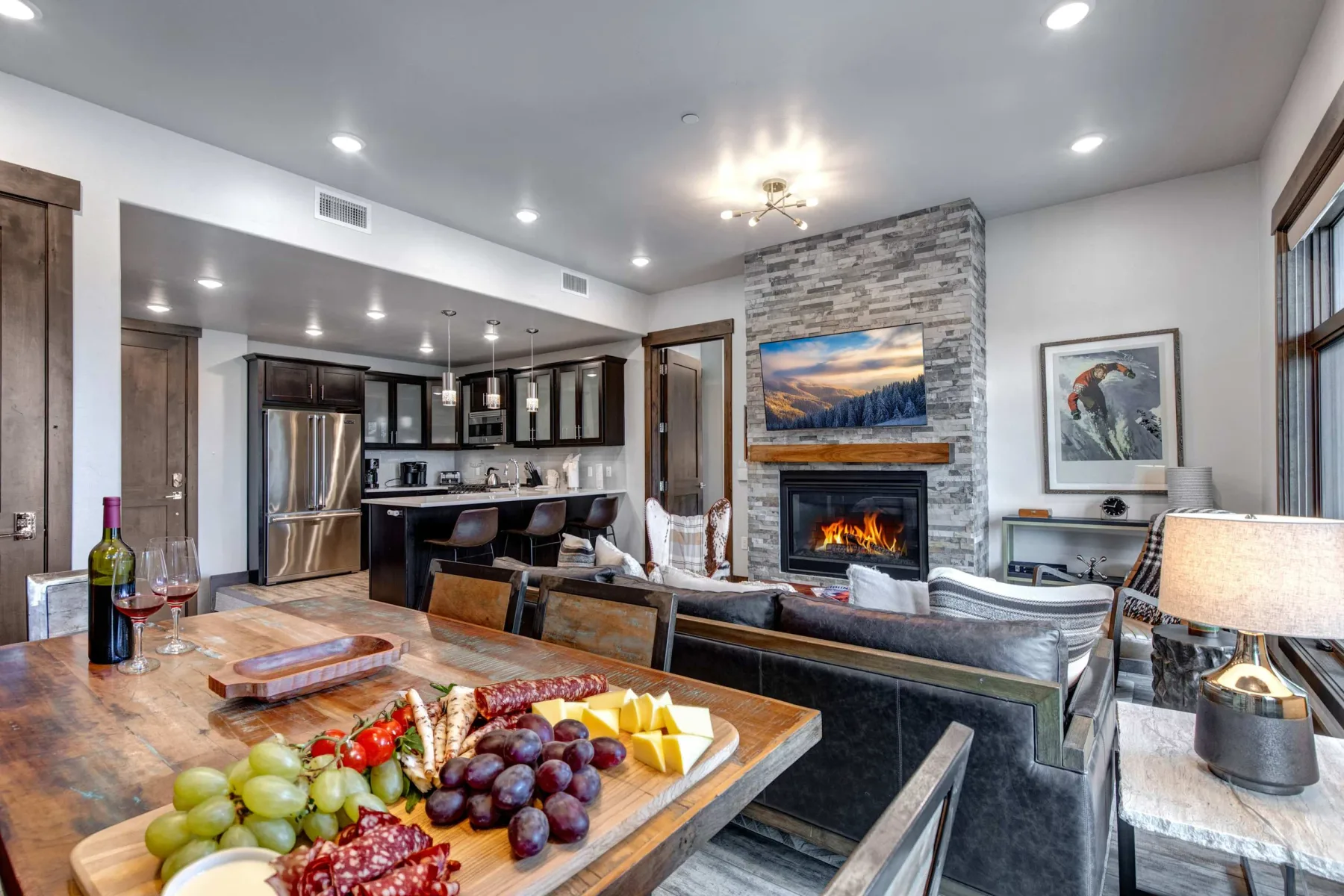 Sala de estar y cocina de planta abierta con chimenea y mesa de comedor.
