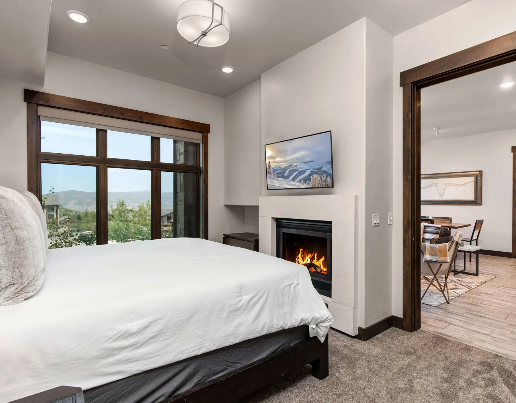Dormitorio con una cama grande, una ventana y una chimenea.
