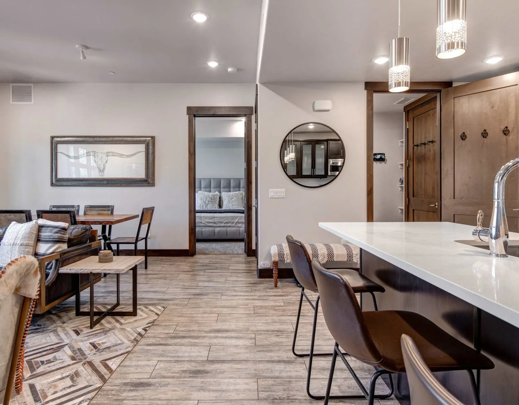 Una estancia moderna y abierta combina un comedor, asientos junto a una barra y una puerta al dormitorio.
