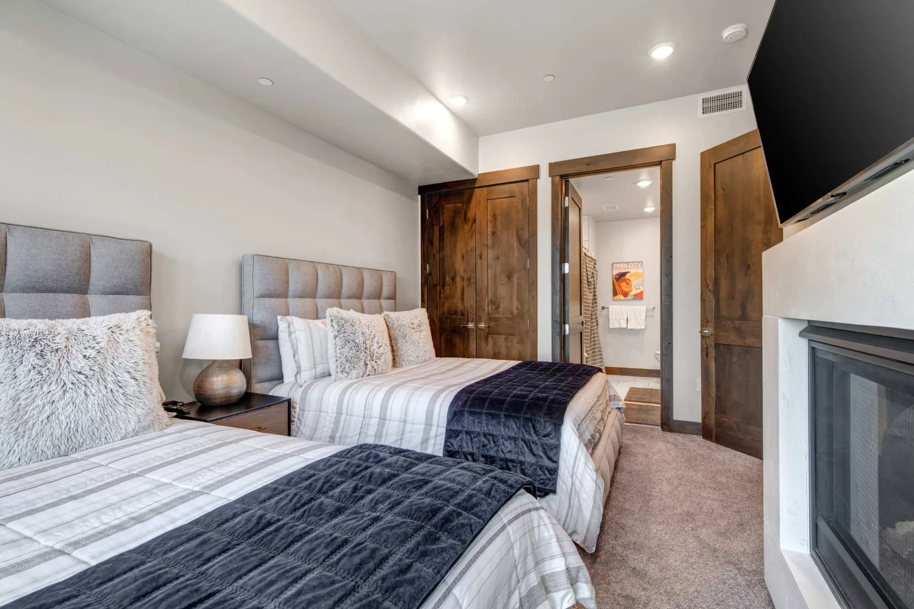 Un dormitorio con dos camas, ropa de cama estampada y una chimenea.