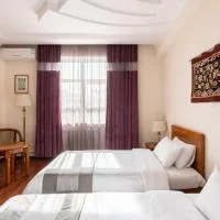 Representative hotel space: A hotel bedroom with two beds, a window, and purple curtains.
