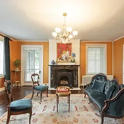Representative hotel space: A living room with a fireplace, seating, and a chandelier.