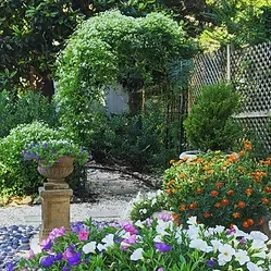 Representative hotel space: A garden path winds through flowering plants and leafy shrubs.