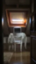 Espacio representativo del hotel: Un comedor tenue con una mesa bajo una lámpara de techo iluminada.