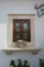 Espacio representativo del hotel: Una ventana enmarcada con paneles de madera oscura está empotrada en una pared clara.