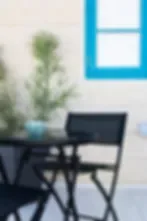Representative hotel space: A seating area with a small table and a plant beside a blue-framed window.