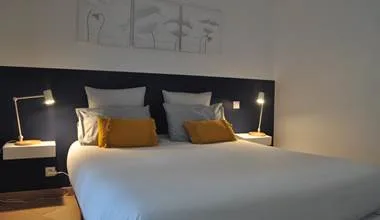 Representative hotel space: A hotel bedroom with a bed and bedside lamps.