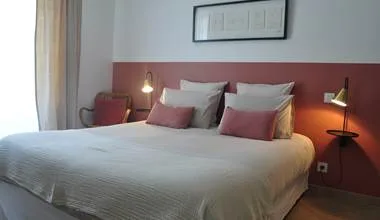 Representative hotel space: A bedroom with a large bed, pillows, and bedside lamps.