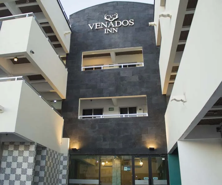 Espacio representativo del hotel: Entrada de hotel con una fachada oscura y puertas de vidrio.