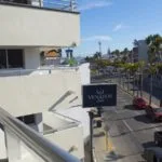 Espacio representativo del hotel: Un balcón exterior da a un estacionamiento y edificios cercanos.