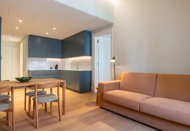 Una sala-comedor de espacio abierto con cocina y sofá.